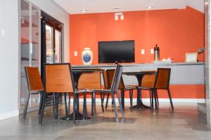 a dining room with a table with chairs and a television at Hotel São Domingos in Feira de Santana