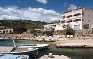 two boats docked in the water in front of a building at Apartments Radic in Rogoznica