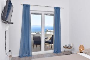 a bedroom with blue curtains and a view of the ocean at Maya's Room in Tučepi
