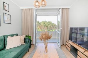a living room with a green couch and a large window at Apartment 93B in Nowa Sól