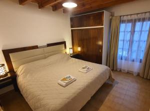 1 dormitorio con 1 cama con 2 toallas en JM Casa Hermosa en Ushuaia