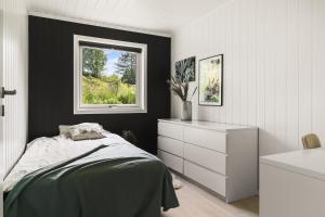 1 dormitorio con cama y ventana en Villa i Bjørnafjorden, en Osøyro