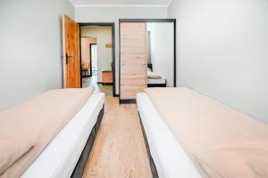 2 łóżka w pokoju z lustrem w obiekcie Apartment 93B w Nowej Soli