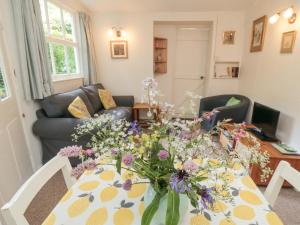 a living room with a table with flowers on it at Damson Croft in York