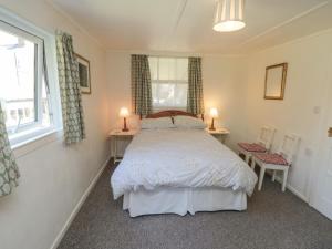 a bedroom with a bed and two chairs and a window at Damson Croft in York