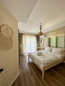 una camera con un grande letto e una grande finestra di Ella Alaçatı Otel a Ildir