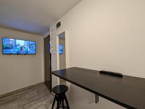 a room with a desk and a tv on the wall at Petite Studio With Ensuite Bathroom in Zagreb