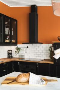 a kitchen with black cabinets and a bread on a cutting board at Villa i Bjørnafjorden in Osøyro