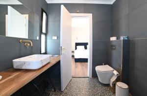 a bathroom with a sink and a toilet and a bedroom at נוף העמק - דירה מהממת עם נוף עוצר נשימה in Nof Kinneret +26 photos