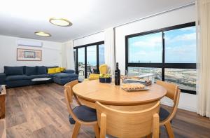 a living room with a table and a couch at נוף העמק - דירה מהממת עם נוף עוצר נשימה in Nof Kinneret