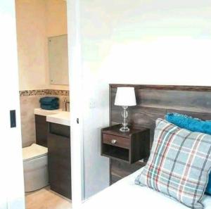 a bedroom with a bed and a bathroom with a sink at The Wee Stay - Room Only - Rural 1 Bed Guest Suite in Middleton Fossoway