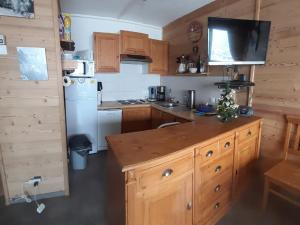 een kleine keuken met houten kasten en een koelkast bij Appartement lumineux 6 pers, 2 ch, départ ski au pied - FR-1-416-94 in La Toussuire +7 foto's