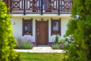a house with a brown door and some flowers at Domki Mazurska Dolina in Mikołajki