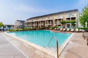 a swimming pool with chairs and a building at Rehoboth Crossing --- 19913 Ames Drive #106 in Rehoboth Beach