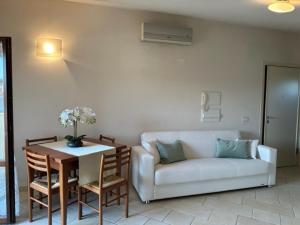 a living room with a couch and a table at Appartamento Perla Marina in Milano Marittima