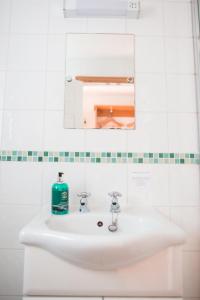 y baño con lavabo blanco y espejo. en The Talbot Arms en Lyme Regis