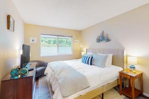 a bedroom with a bed and a desk and a television at Neskowin Nautical Nook in Neskowin