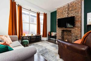 uma sala de estar com um sofá e uma lareira em Orange Rentals-Characteristic Victorian terrace 5 bedroom house em Liverpool