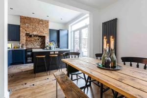 eine Küche und ein Esszimmer mit einem Holztisch und Stühlen in der Unterkunft Orange Rentals-Characteristic Victorian terrace 5 bedroom house in Liverpool
