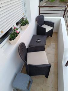 two chairs and a table on a balcony at Finesi apartments 3 in Ohrid +1 photo