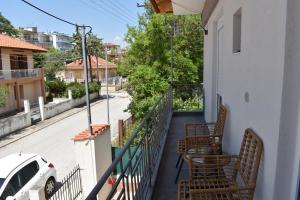 a balcony with chairs and a table on a house at Kefala Luxury Living in Nea Kalikratia