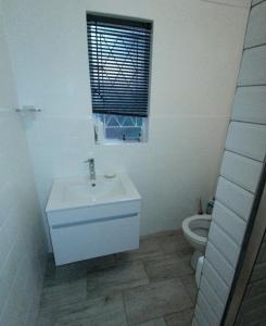 a white bathroom with a sink and a toilet at Yalta Park in Pietermaritzburg