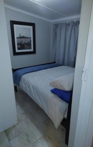 a small bedroom with two beds and a picture on the wall at Yalta Park in Pietermaritzburg