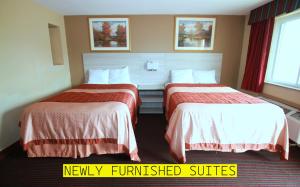 ein Hotelzimmer mit 2 Betten mit roter und weißer Bettwäsche in der Unterkunft Travel Inn & Suites Flemington in Flemington