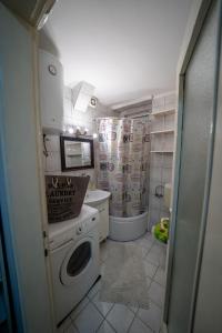 een kleine keuken met een wasmachine en droger bij Apartman Daris in Sarajevo