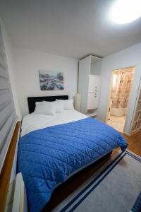 een slaapkamer met een groot bed en een blauw dekbed bij Apartman Daris in Sarajevo