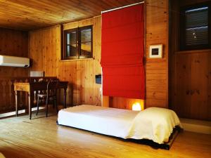 um quarto com uma cama com uma cabeceira vermelha e uma secretária em L'abete, bilocale su due piani in centro storico em Sondrio