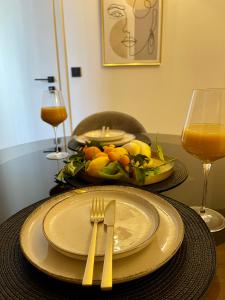 a table with a plate and fork and a glass of orange juice at Holiday Home Mirela in Orebić