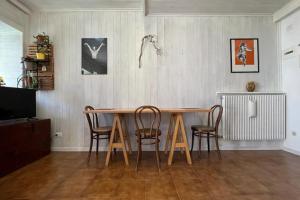 una sala da pranzo con tavolo e sedie in legno di L'abete, bilocale su due piani in centro storico a Sondrio