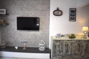 a living room with a tv on a brick wall at Kefala Luxury Living in Nea Kalikratia