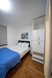 een slaapkamer met een bed en een witte kast bij Apartman Daris in Sarajevo