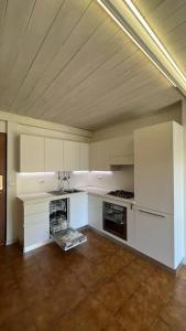 uma cozinha com armários brancos e um tecto de madeira em L'abete, bilocale su due piani in centro storico em Sondrio