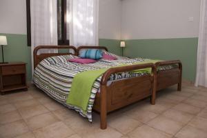a bedroom with a wooden bed with pillows on it at El Marco Villa in Pissouri