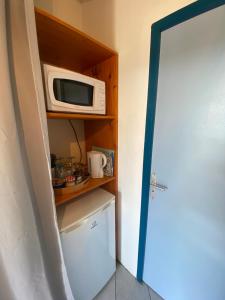 a microwave sitting on a shelf next to a refrigerator at La Baie du Bonheur in Deshaies