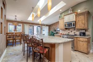 a kitchen with wooden cabinets and a island with bar stools at Large Sedona Property with Private Pool! 7 Bedrooms! in Sedona