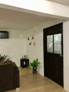 uma sala de estar com uma porta e um sofá em lindo departamento independiente em Taxco de Alarcón