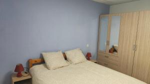 1 dormitorio con 1 cama y vestidor con espejo en La maison de Soso, en Capendac