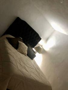 um quarto com uma cama com almofadas em lindo departamento independiente em Taxco de Alarcón