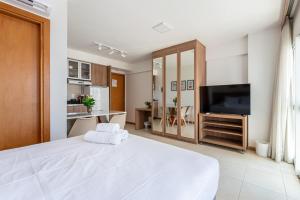 巴西利亚BSB STAY Premium Flats Particulares - Saint Moritz的卧室里有一张白色的大床和一台电视