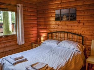 a bedroom with a bed in a log cabin at Larch Lodge - Uk37187 in Legbourne