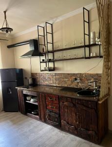 a kitchen with a counter with a sink and a refrigerator at Милый Дом in Vanadzor