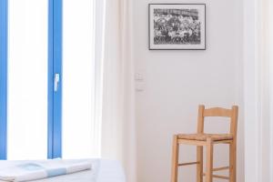 een slaapkamer met een stoel en een foto aan de muur bij Sealit Deluxe Apartment in Drios