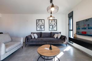 un soggiorno con divano e tavolo di O&O Group - Luxury APT/3 BR/New Tower/Parking a Or Yehuda