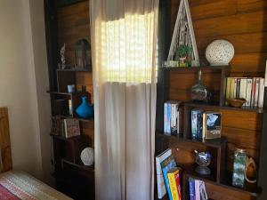 a book shelf with a curtain next to a window at La Baie du Bonheur in Deshaies