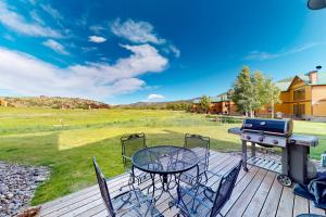 a deck with a table and chairs and a grill at San Juan Siesta in South Fork