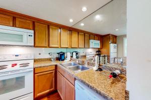 a kitchen with white appliances and wooden cabinets at Hemlock Nob B11 in Sugar Mountain